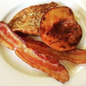 Croissant french toast with baked peaches and bacon